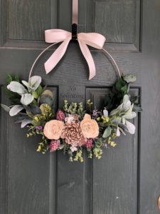 Spring embroidery hoop wreath with peach and pink flowers and greenery leaves.