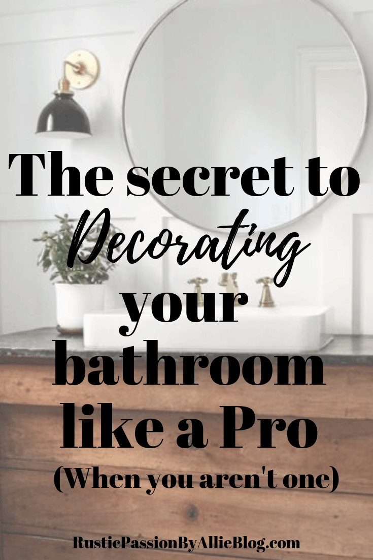 White Bathroom with a wood vanity and a large round mirror text overlay - The secret to decorating your bathroom like a pro when you aren't one
